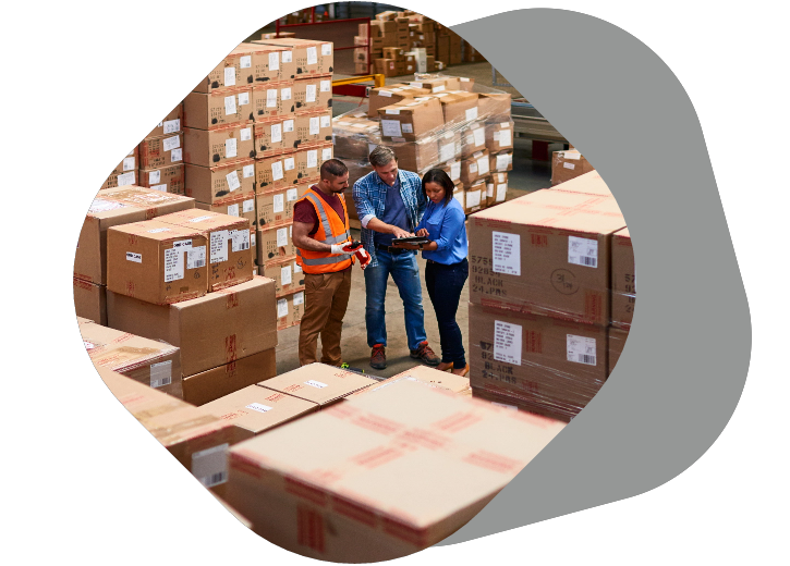 People looking over order sheet in a warehouse surrounded by boxes, seamless fulfillment